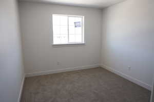 Carpeted empty room featuring baseboards