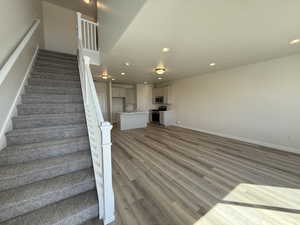 Stairs featuring baseboards, wood finished floors, and recessed lighting