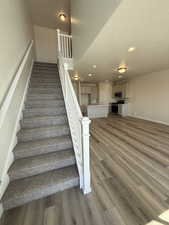 Staircase with recessed lighting, baseboards, and wood finished floors