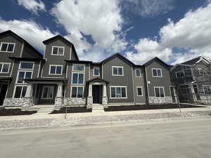 View of front facade featuring stone siding and board and batten siding