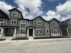 View of front facade featuring stone siding and board and batten siding