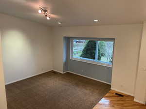 Vaulted living room area with vaulted ceiling, box window, and recessed lighting.