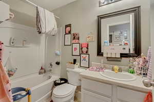 Full bath with toilet, vanity, and bathing tub / shower combination