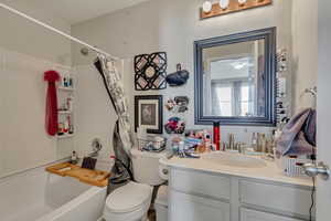 Bathroom with toilet, vanity, and shower / bath combo with shower curtain