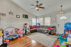 Playroom featuring a ceiling fan, vaulted ceiling, and wood finished floors