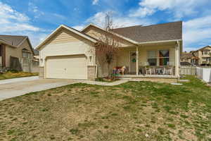 Ranch-style home with fence, a garage, concrete driveway, a front yard, and a porch
