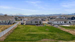 Back of property with a mountain view, a patio, a fenced backyard, and a residential view