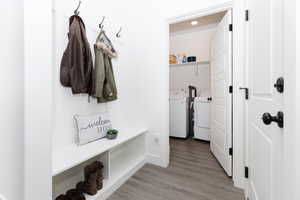 Mudroom with light wood-style flooring and washing machine and clothes dryer
