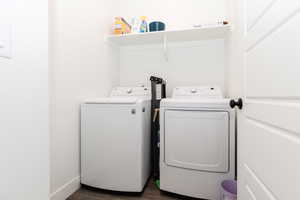 Laundry area with washer and clothes dryer, laundry area, and dark wood finished floors