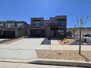 Contemporary house featuring a garage, stucco siding, driveway, and a residential view