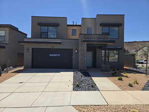 Contemporary house with stucco siding, concrete driveway, and an attached garage
