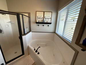Bathroom with a shower stall and a whirlpool tub