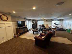 Living room with a wealth of natural light, a decorative wall, and carpet floors