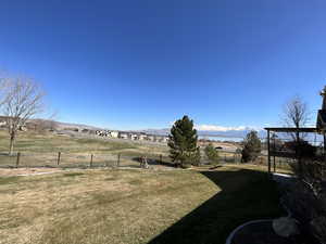 View of yard with a mountain view and fence