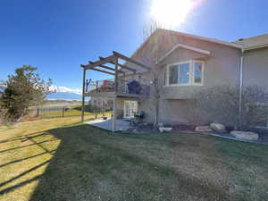 Rear view of property with stucco siding, fence, a patio, french doors, and a yard