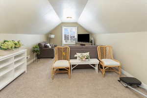 Loft area, lofted ceiling, a textured ceiling, and light carpet
