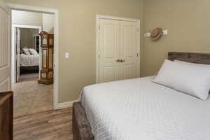 Bedroom with a closet, baseboards, and wood finished floors