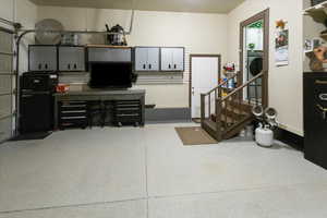 Garage with baseboards and freestanding refrigerator