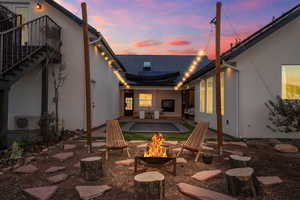 Patio terrace at dusk with a fire pit, ac unit, and stairway