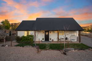 View of front of property featuring metal roof, stucco siding, and a patio area