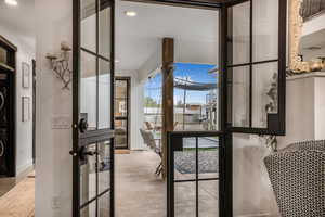 Doorway to outside with stacked washer and dryer and recessed lighting