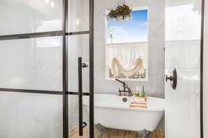 Bathroom featuring a soaking tub and tile walls