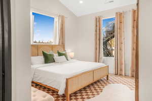 Bedroom featuring lofted ceiling, visible vents, recessed lighting, and light floors