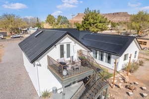 Back of house featuring french doors, metal roof, stucco siding, and solar panels