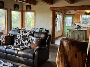 Living room with light tile patterned floors and beamed ceiling