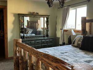 Carpeted bedroom with an inviting chandelier