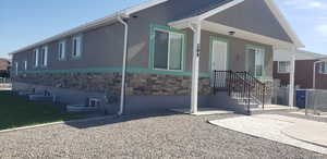 Rear view of property with stone siding and stucco siding