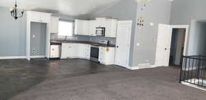 Kitchen with appliances with stainless steel finishes, dark countertops, a sink, baseboards, and tasteful backsplash