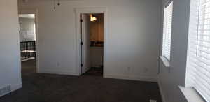 Unfurnished bedroom featuring carpet and baseboards