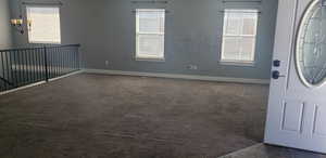 Carpeted entrance foyer featuring baseboards and healthy amount of natural light