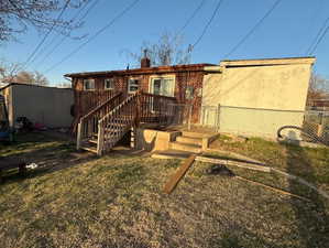 Back of house featuring fence, and brick siding with large storage shed.