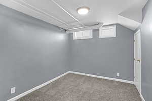Basement with baseboards and carpet