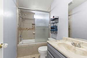 Bathroom featuring tiled shower / bath combo, visible vents, toilet, and vanity