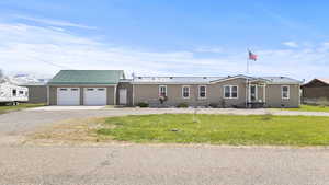 View of front of home with aphalt driveway, metal roof, entry steps, crawl space, and a garage
