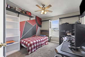 Carpeted bedroom featuring baseboards and ceiling fan