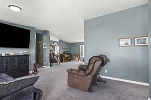 Living area featuring arched walkways, carpet, and baseboards
