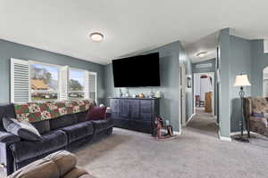 Living room with carpet floors, visible vents, and baseboards