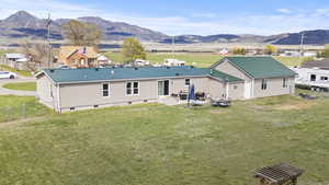 Back of house with crawl space, fence, a mountain view, and metal roof