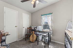 Carpeted home office featuring baseboards and ceiling fan