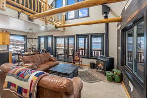 Living room featuring a towering ceiling, baseboards, a wood stove, and a textured ceiling