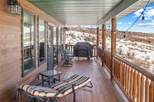 Snow covered deck with a grill