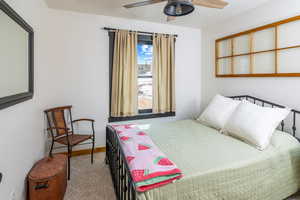 Carpeted bedroom featuring baseboards and a ceiling fan