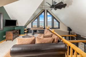 Living area with baseboards, vaulted ceiling, ceiling fan, and carpet flooring