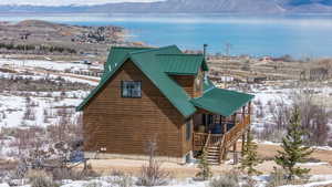 Exterior space featuring metal roof, a water and mountain view, and stairway