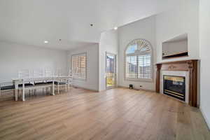 Living area featuring a fireplace, wood finished floors, baseboards, and recessed lighting