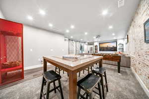 Home Theater room with included screen & projector, faux brick accent wall, barn door and newer carpet.